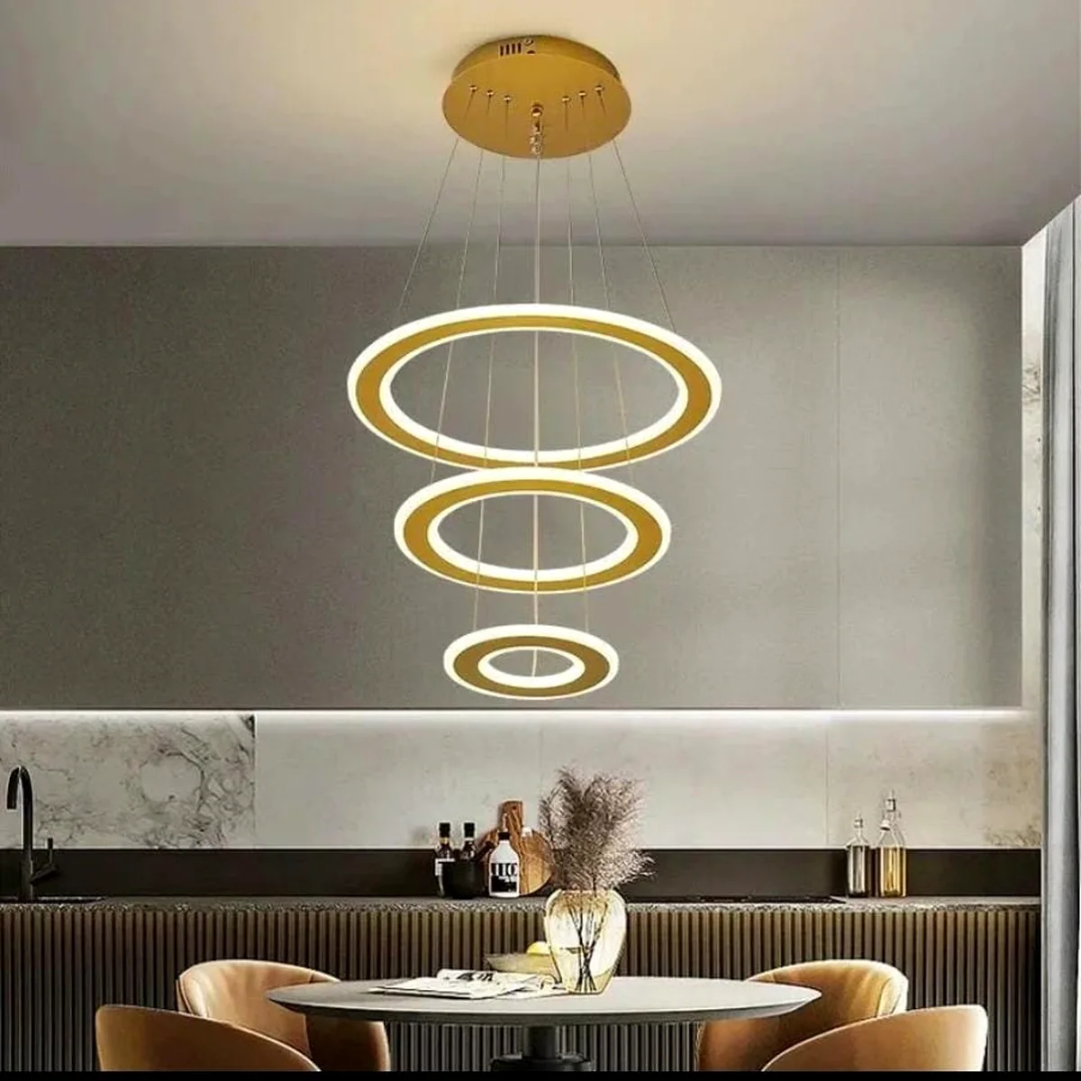 Gold three-tier halo ring chandelier above a dining table